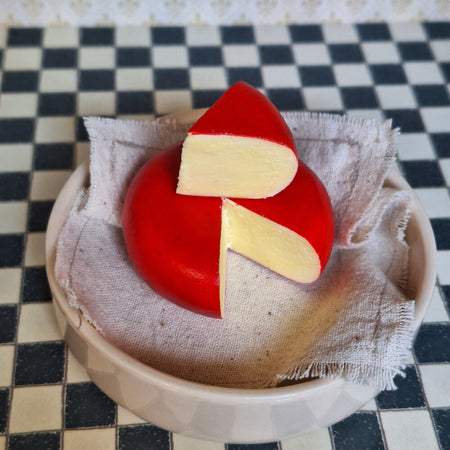 GOUDA cheese wheel with a cut wedge