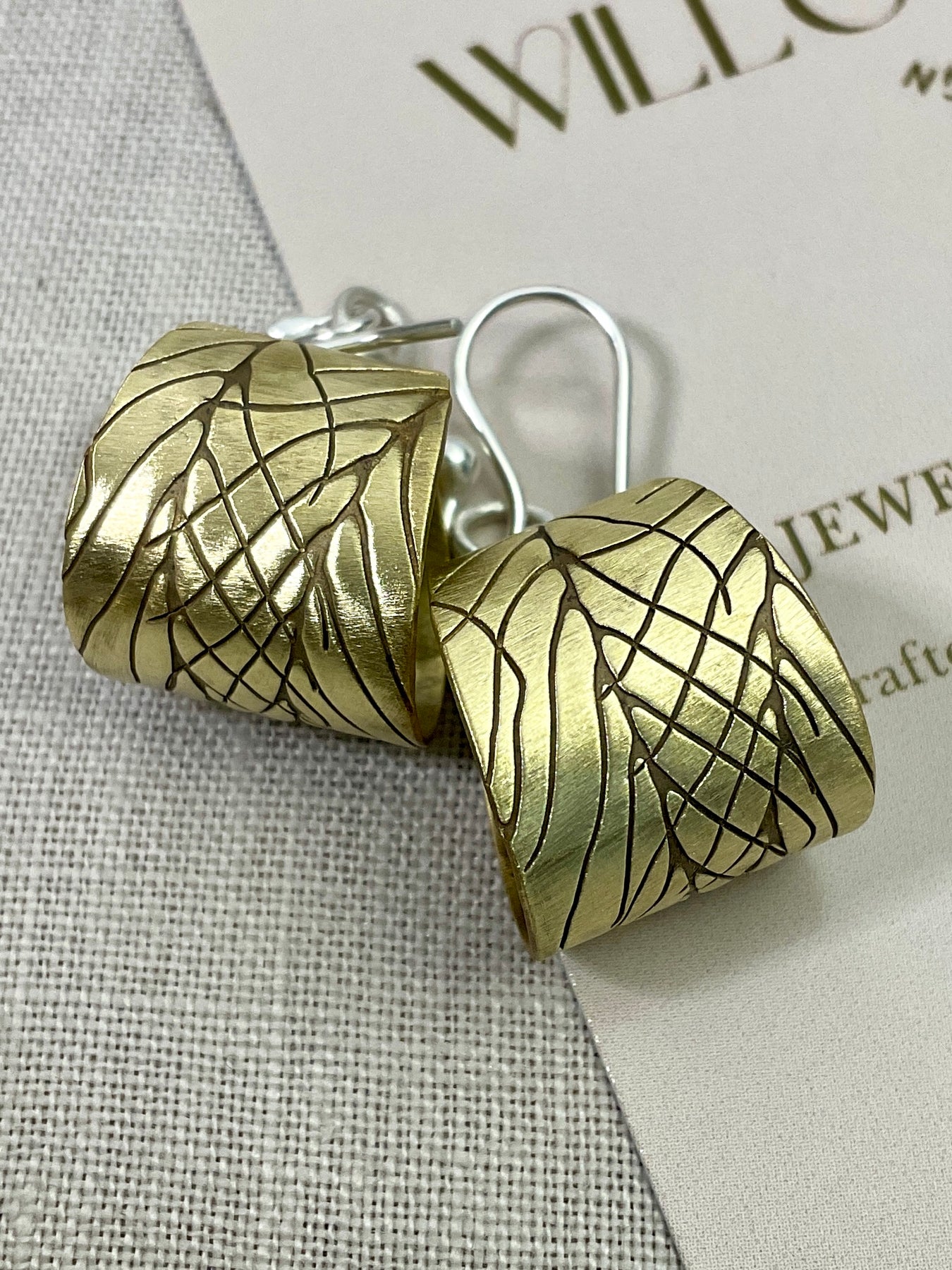 Embossed brass earrings with gemstones.