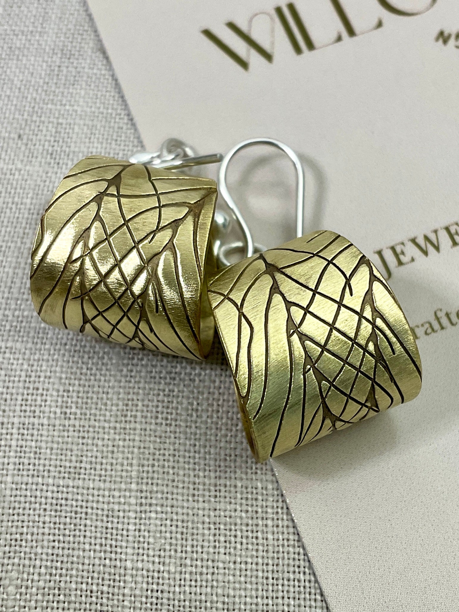 Embossed brass earrings with gemstones.