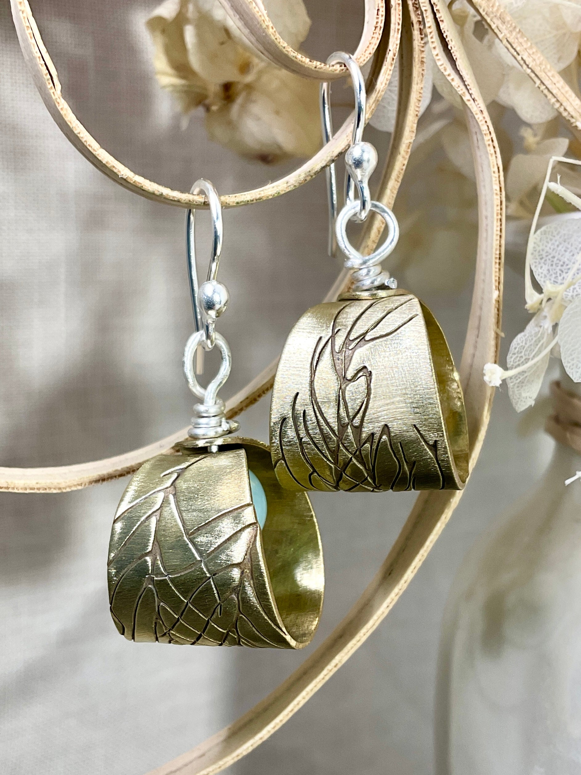 Embossed brass earrings with gemstones.
