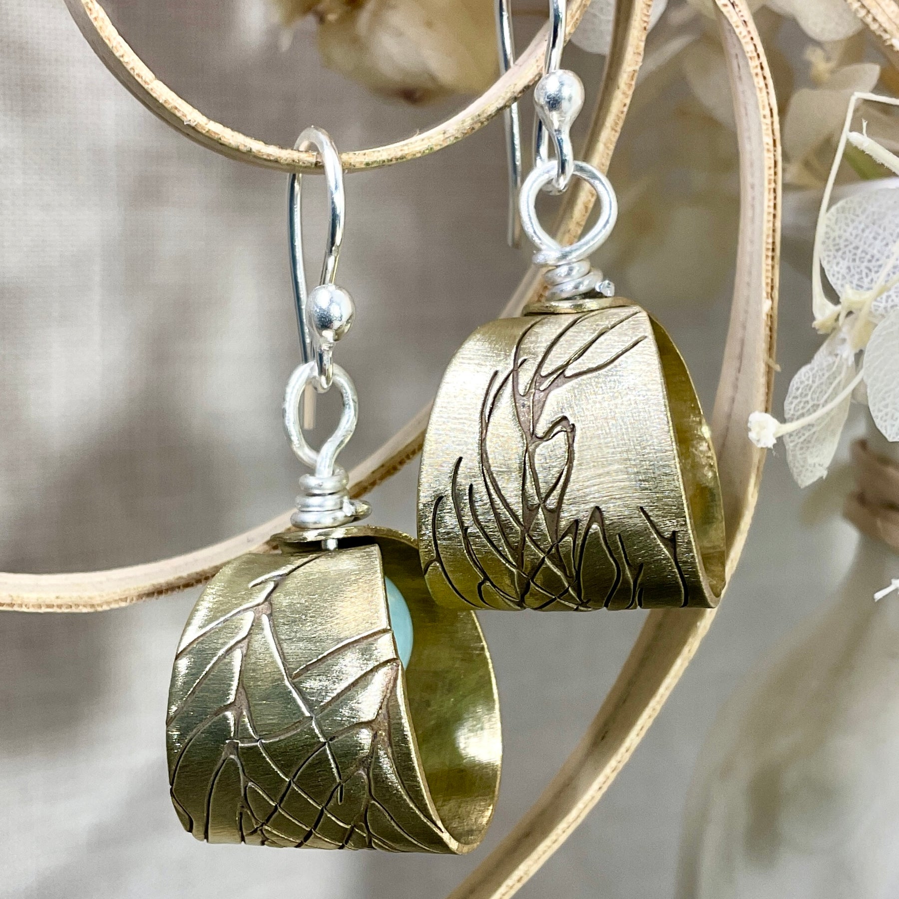 Embossed brass earrings with gemstones.