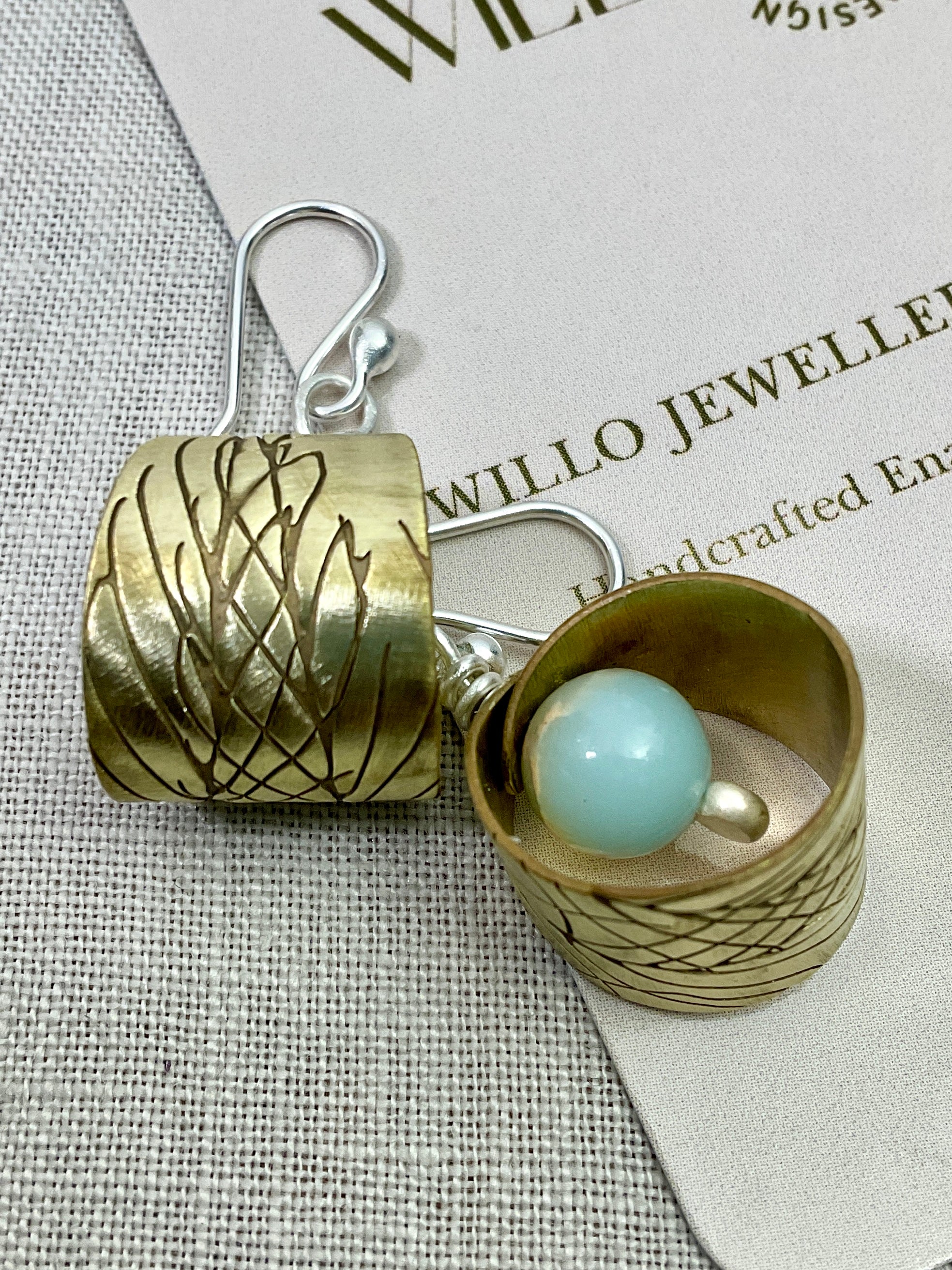 Embossed brass earrings with gemstones.