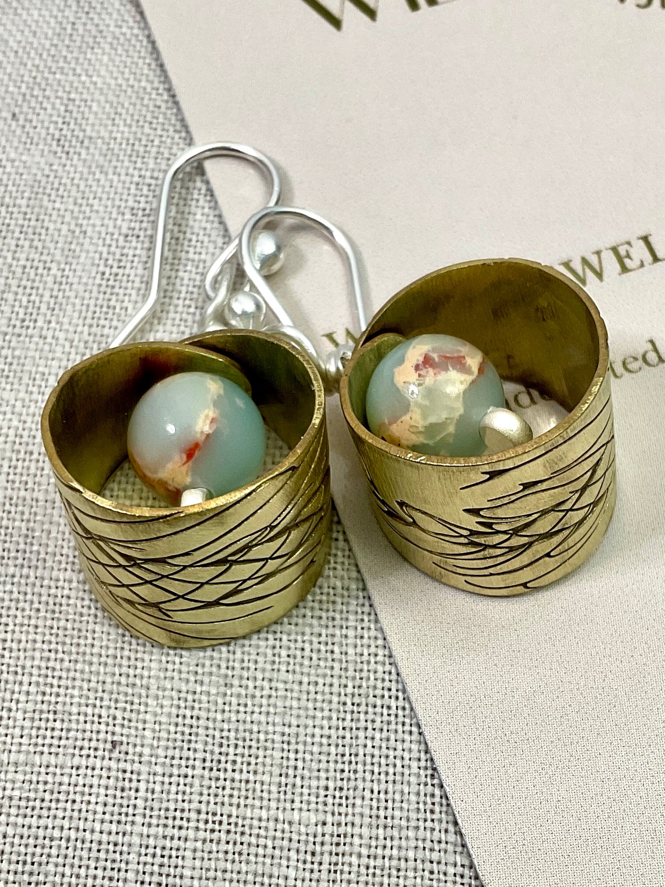 Embossed brass earrings with gemstones.