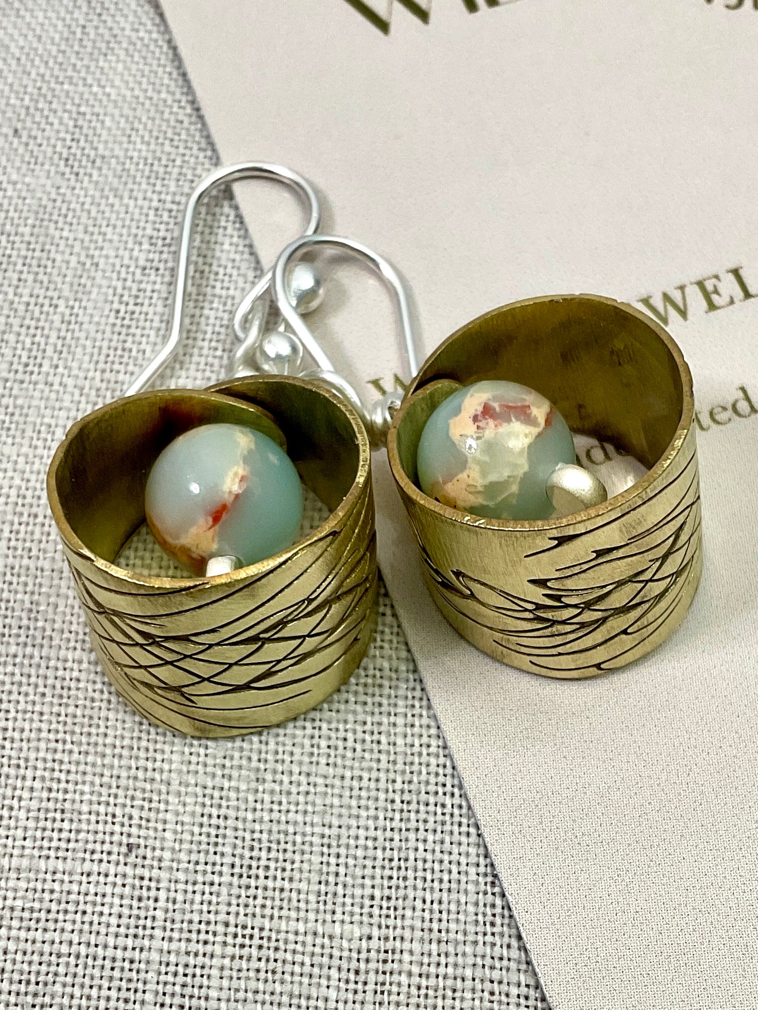 Embossed brass earrings with gemstones.