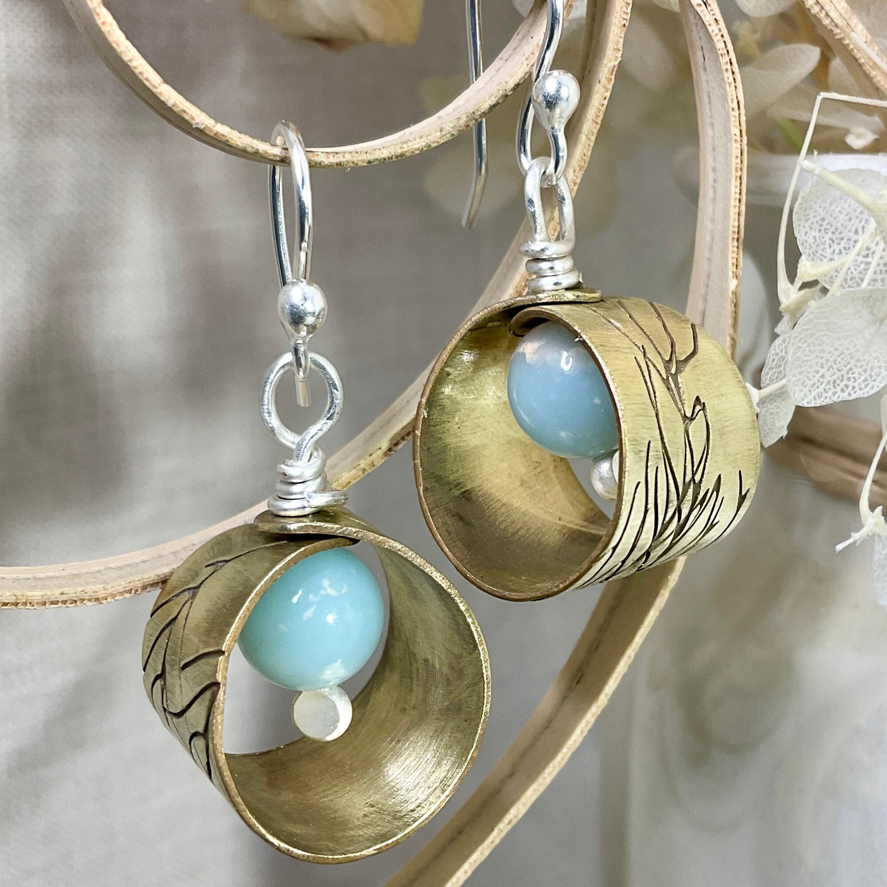 Embossed brass earrings with gemstones.