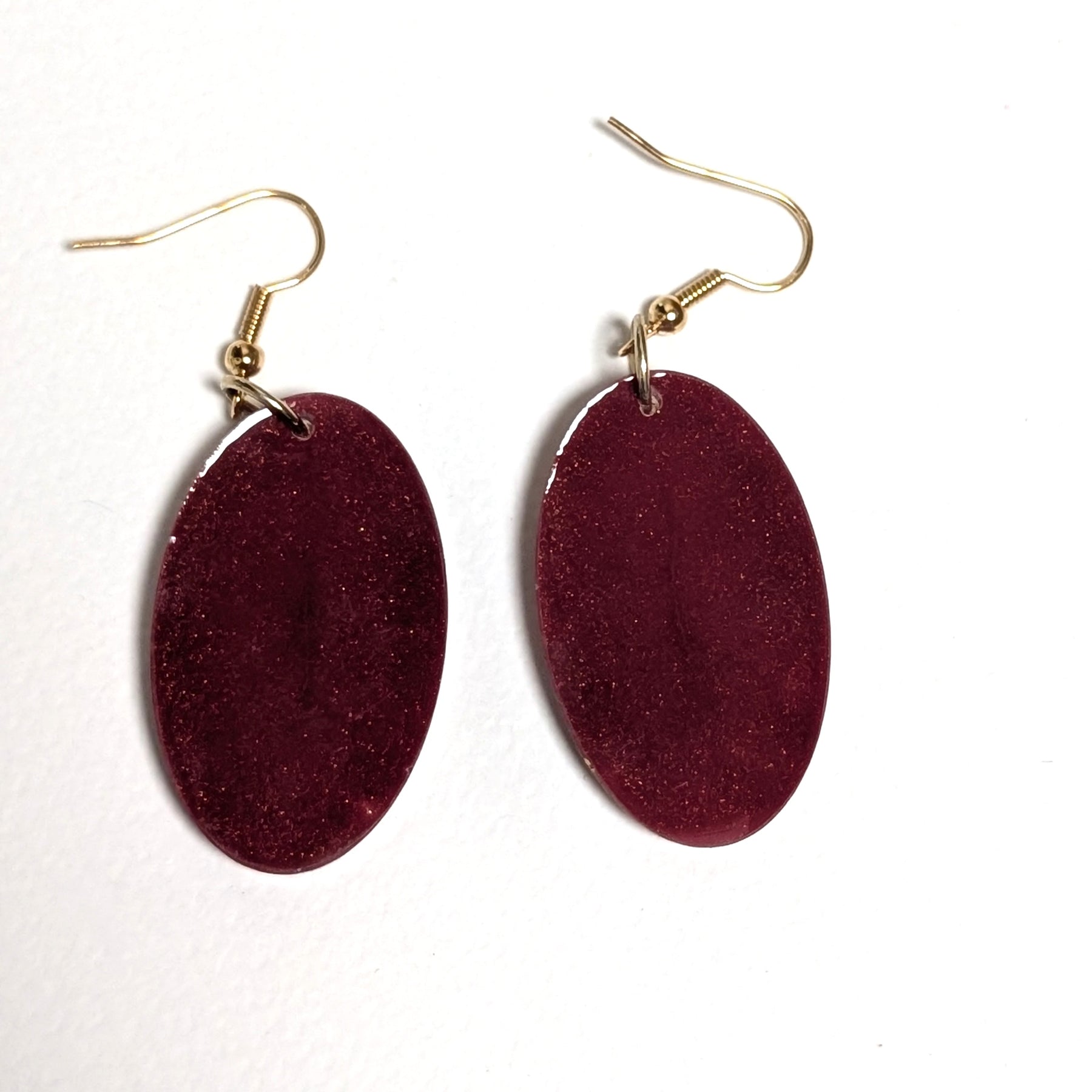 Real daisy earrings with merlot background