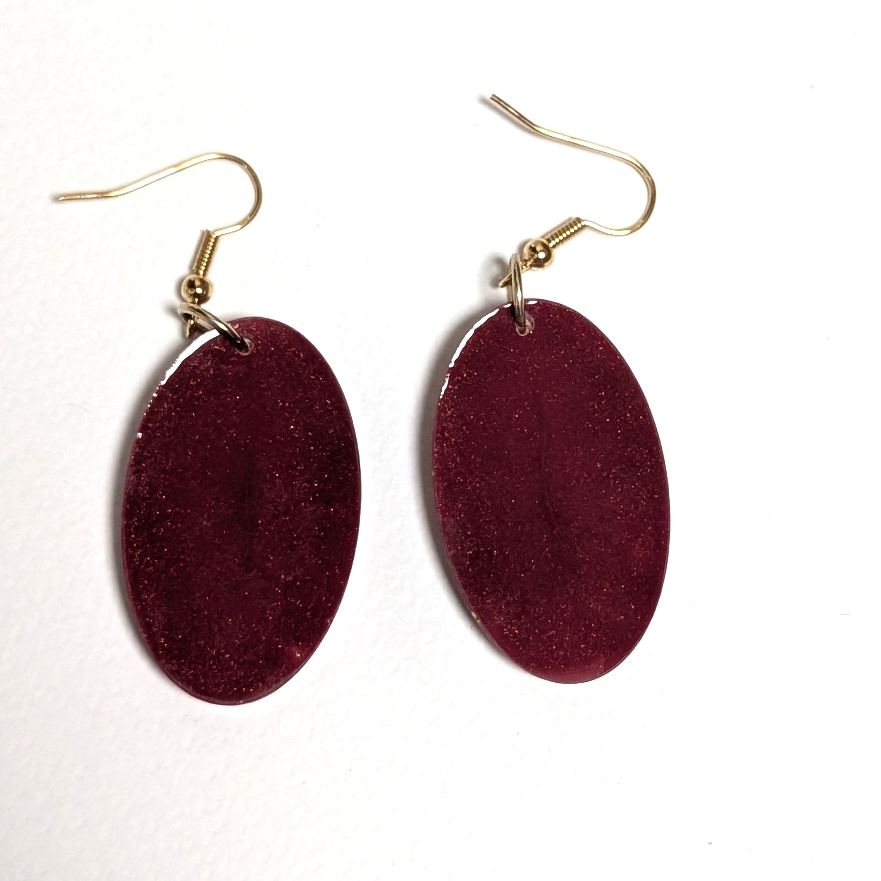 Real daisy earrings with merlot background