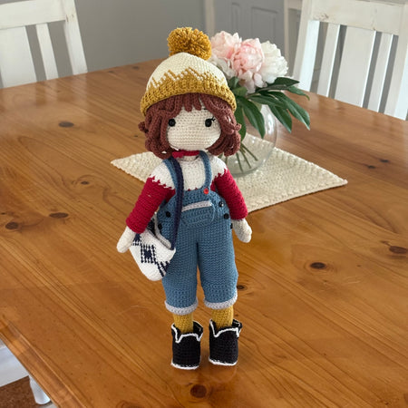 Crochet doll in overalls and beanie.