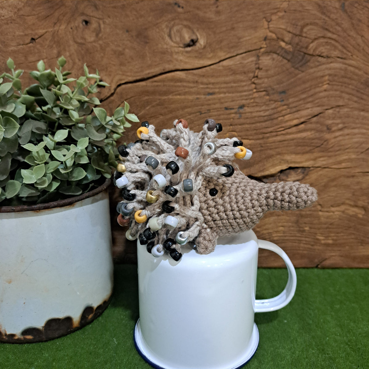 Handmade crochet echidna in beige cotton with neutral coloured beads