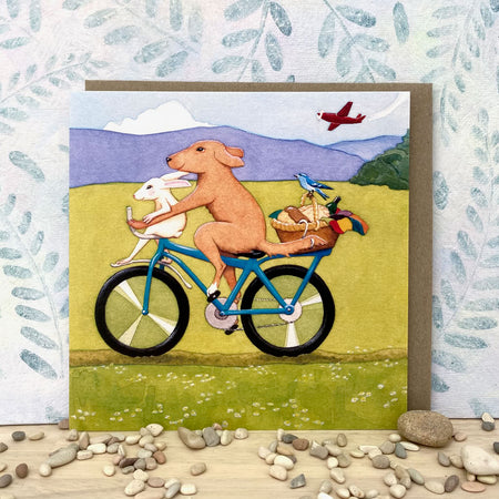 Whimsical Dog and Rabbit on a Bicycle Eco-card (sq-perf)