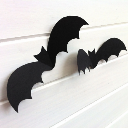 Halloween Bat shapes. Black 3D bats, Spooky holiday decorations.