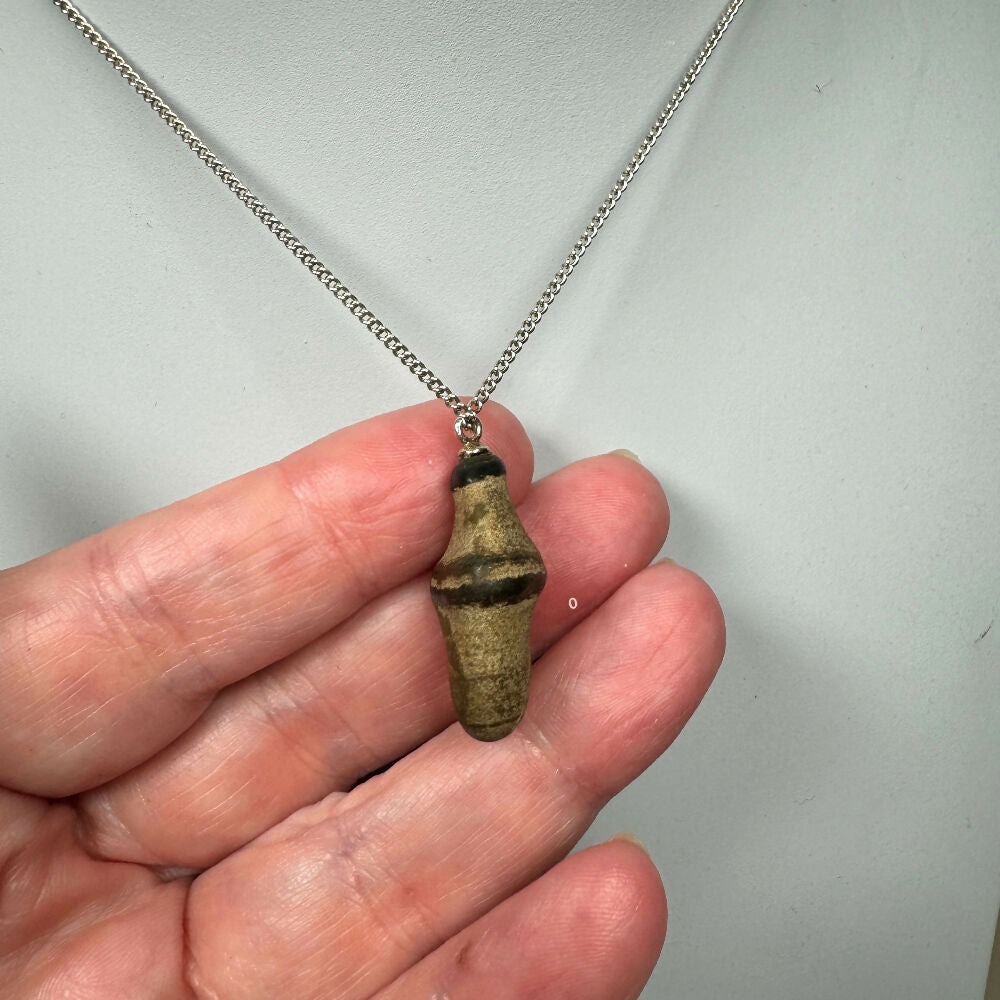 Pebble necklace side view on hand