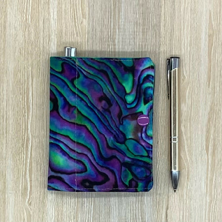 Paua shell refillable fabric pocket notepad cover with snap closure. Incl. book and pen.