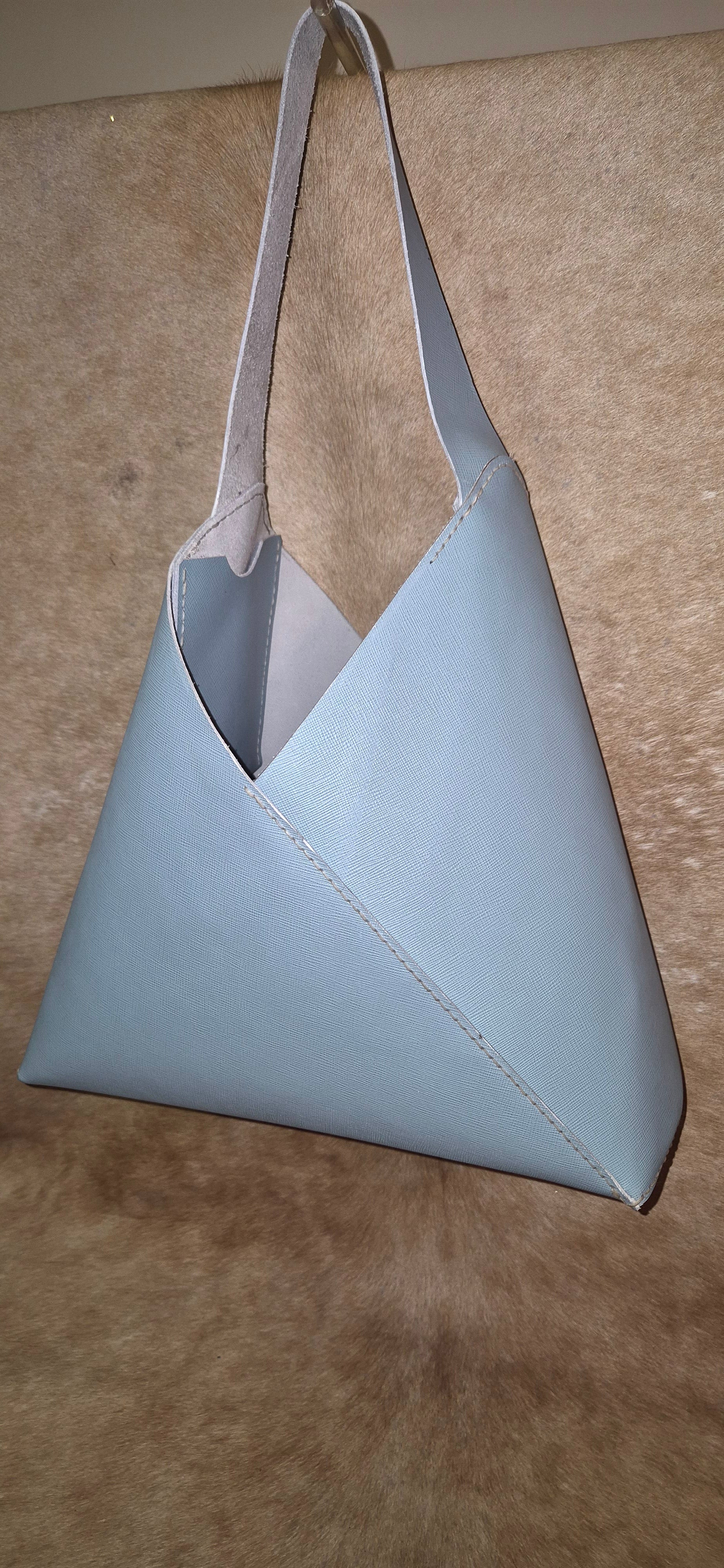 Light blue leather Saffiano triangular unlined handbag.