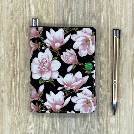 Pink floral refillable fabric pocket notepad cover with snap closure. Incl. book and pen.