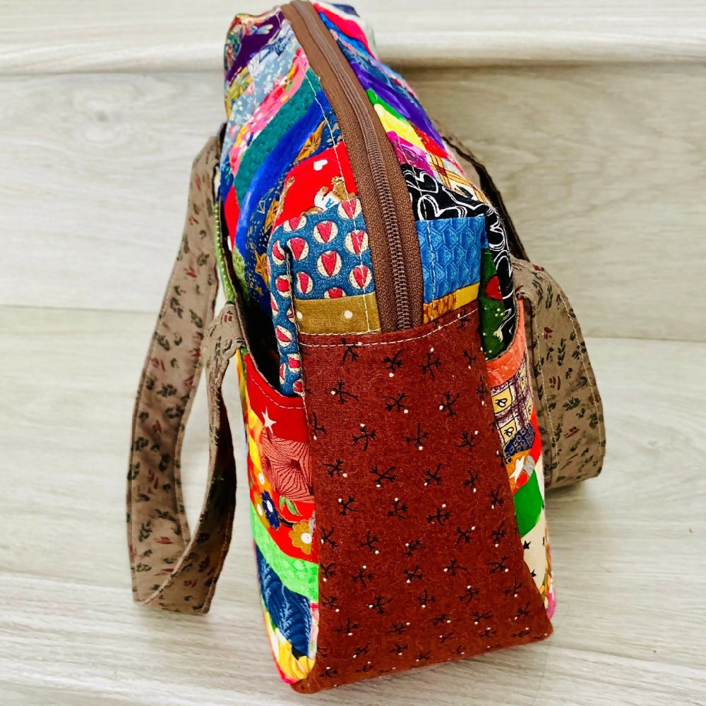 Compact curved gusseted patchwork handbag