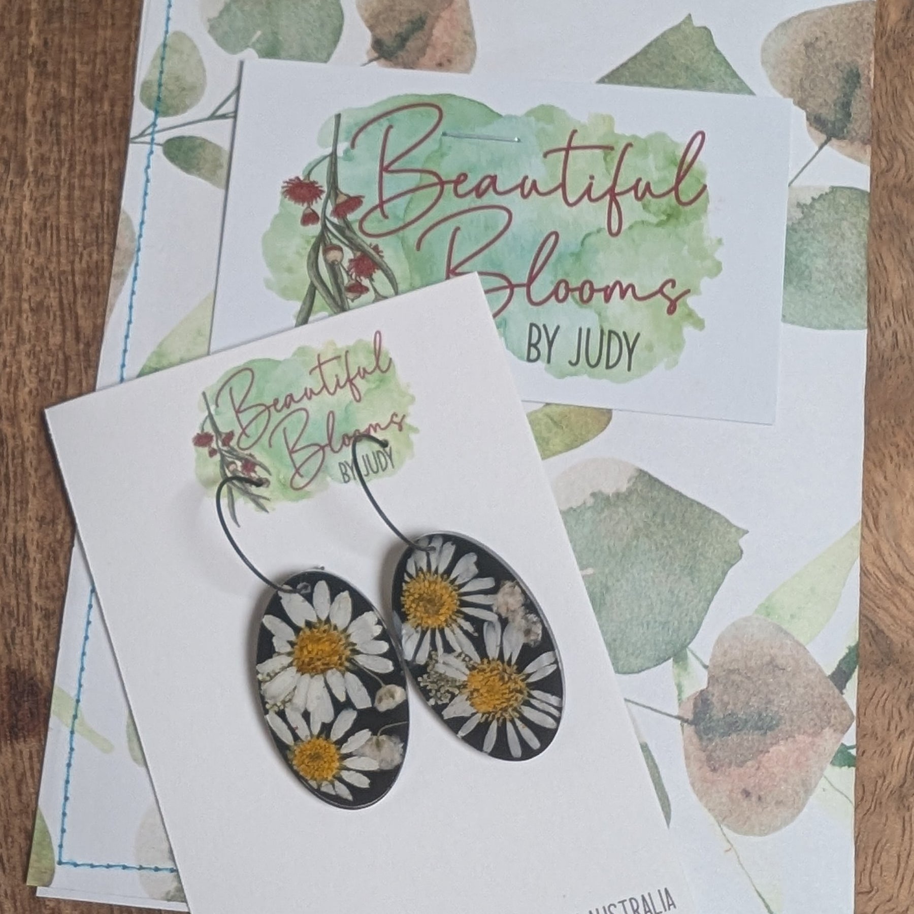 Real flower earrings, daisies, black background