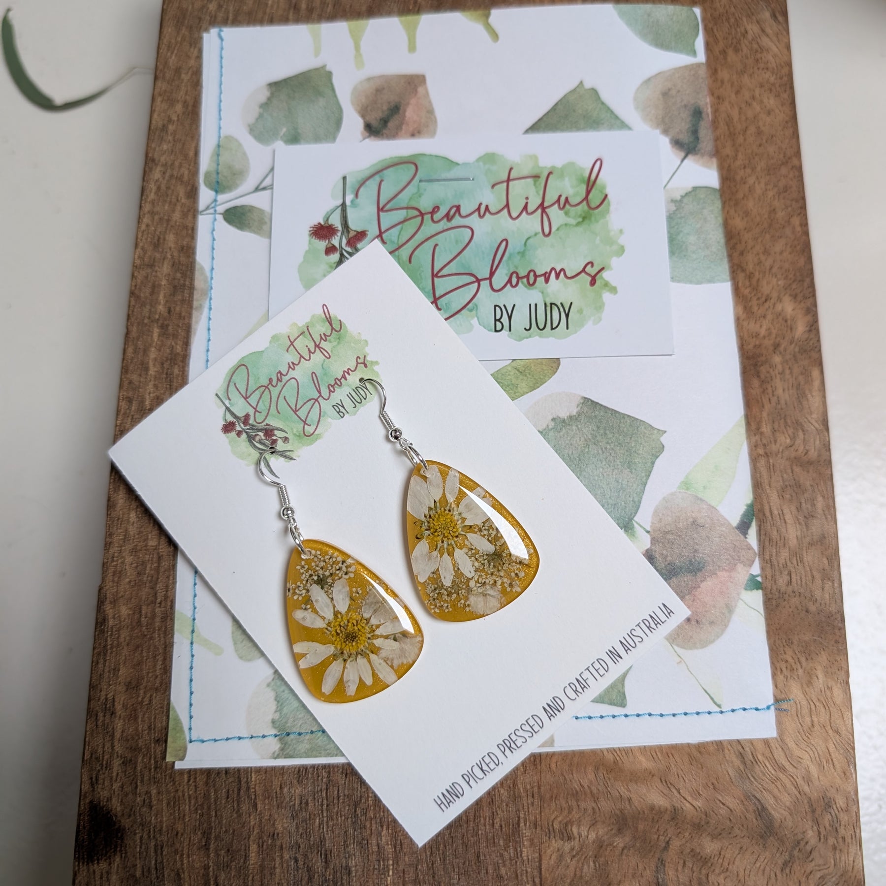Real daisies in resin, mustard background
