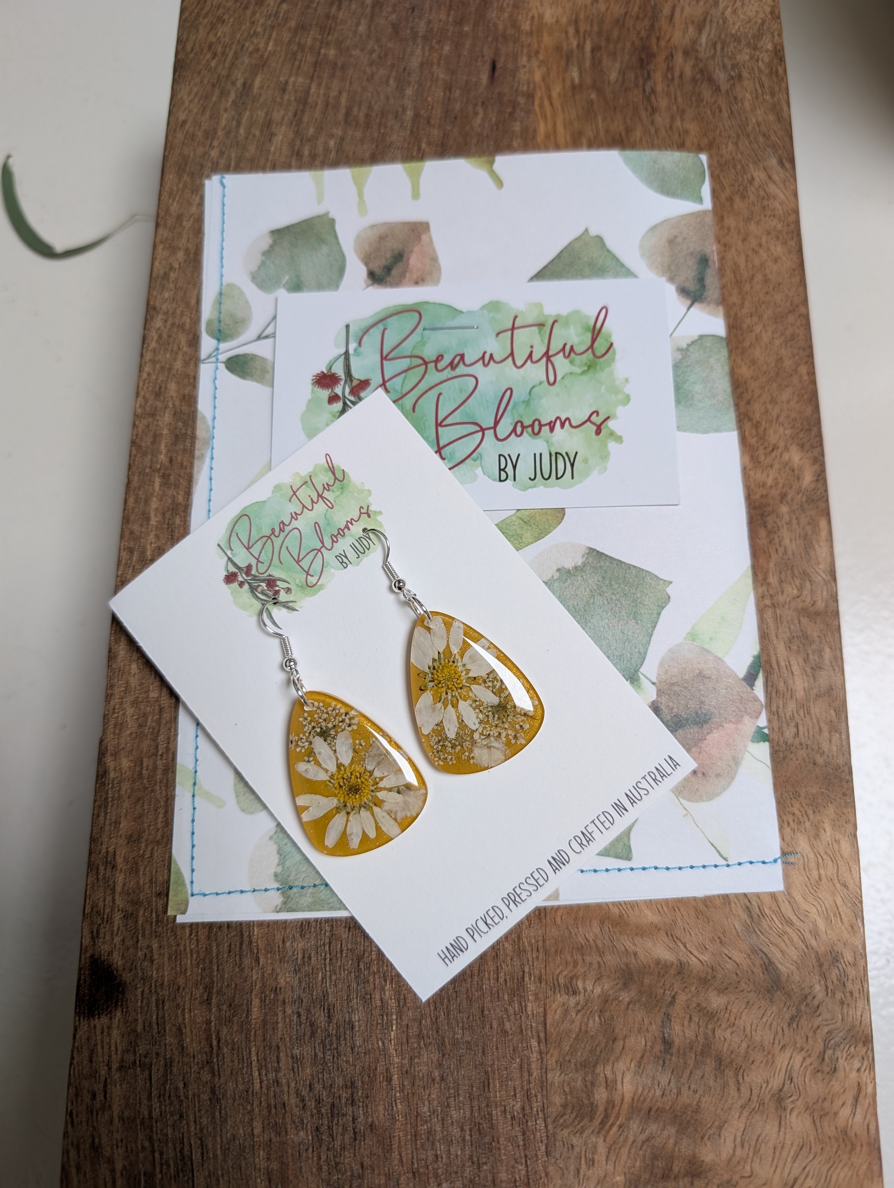 Real daisies in resin, mustard background