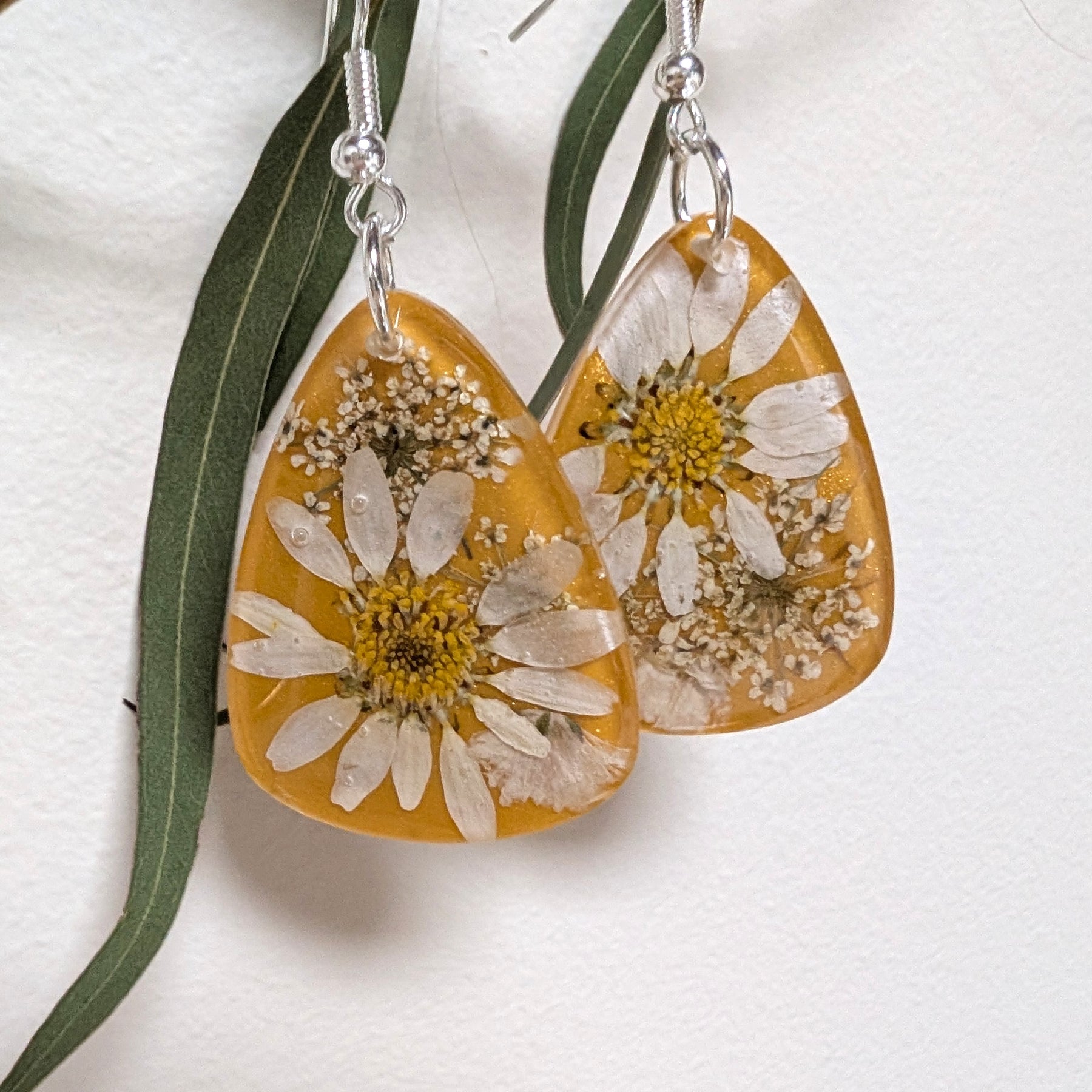 Real daisies in resin, mustard background