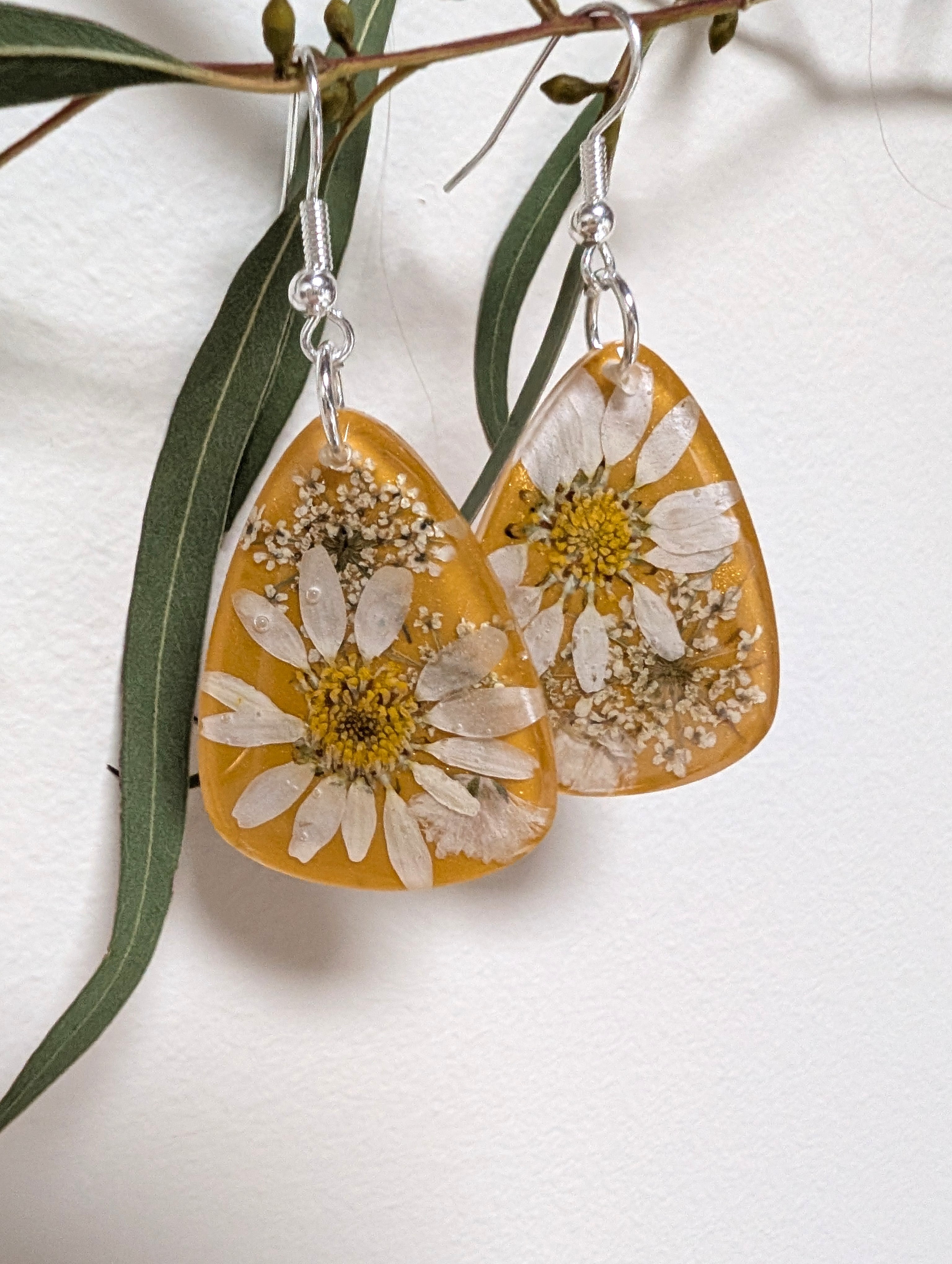 Real daisies in resin, mustard background
