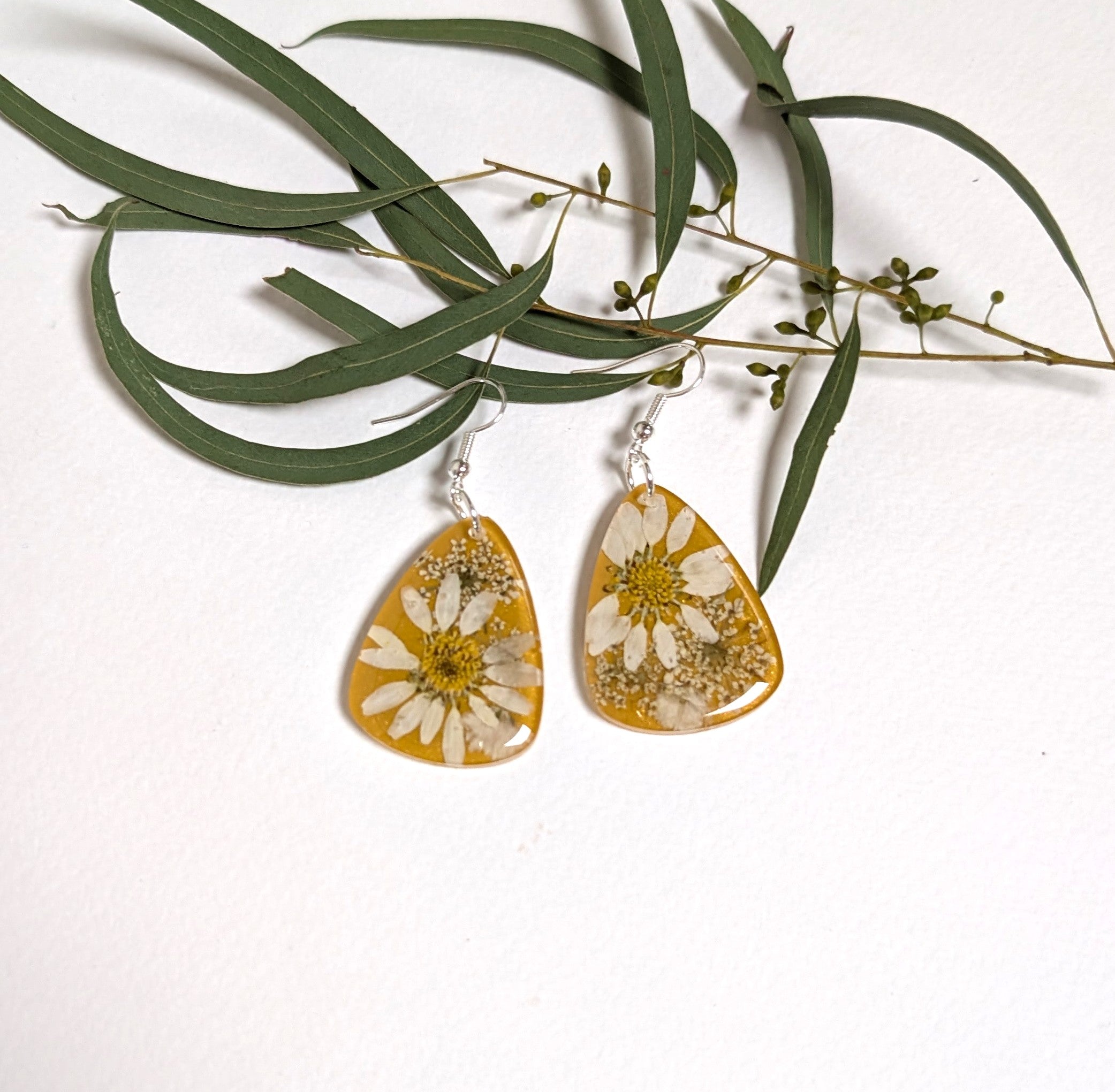 Real daisies in resin, mustard background
