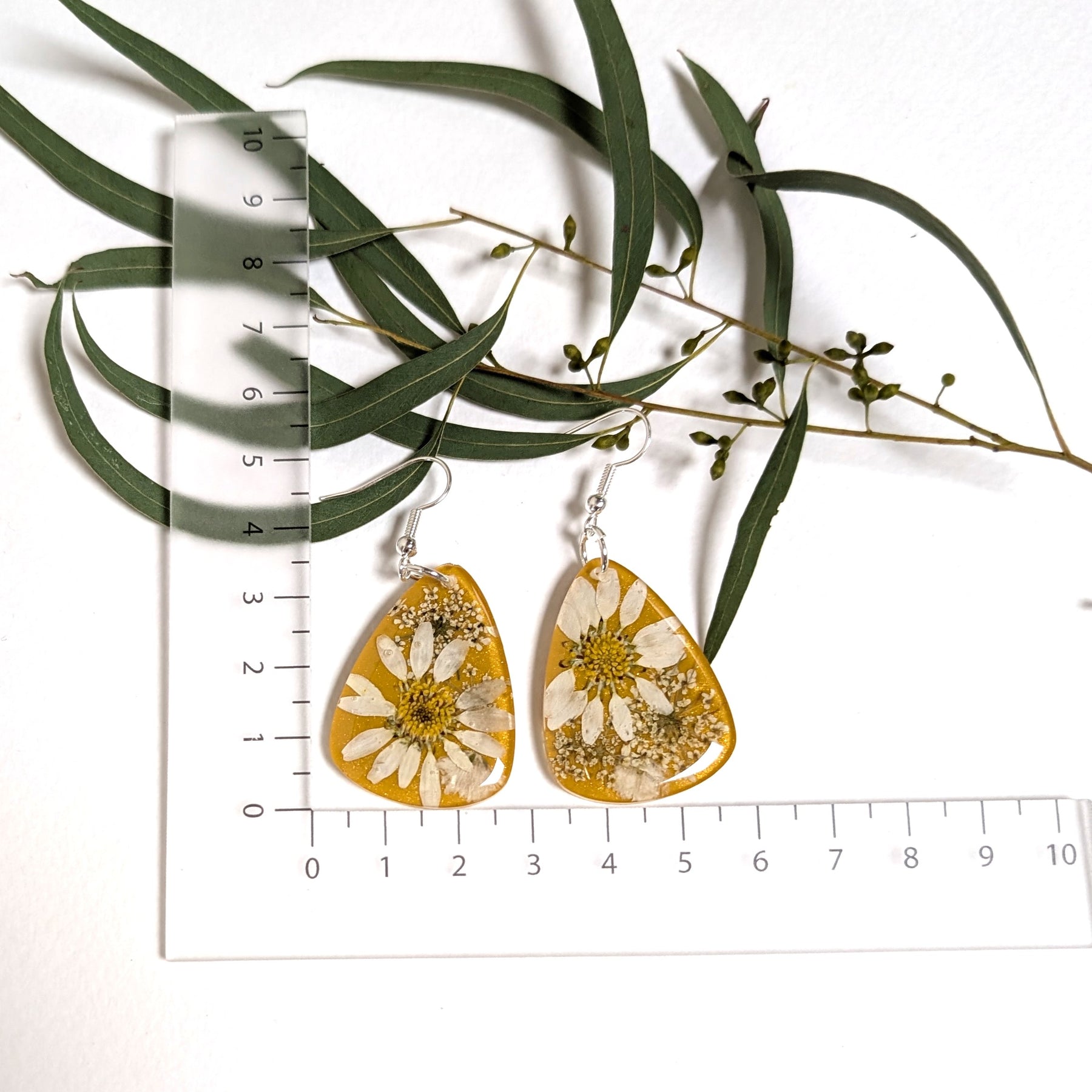 Real daisies in resin, mustard background