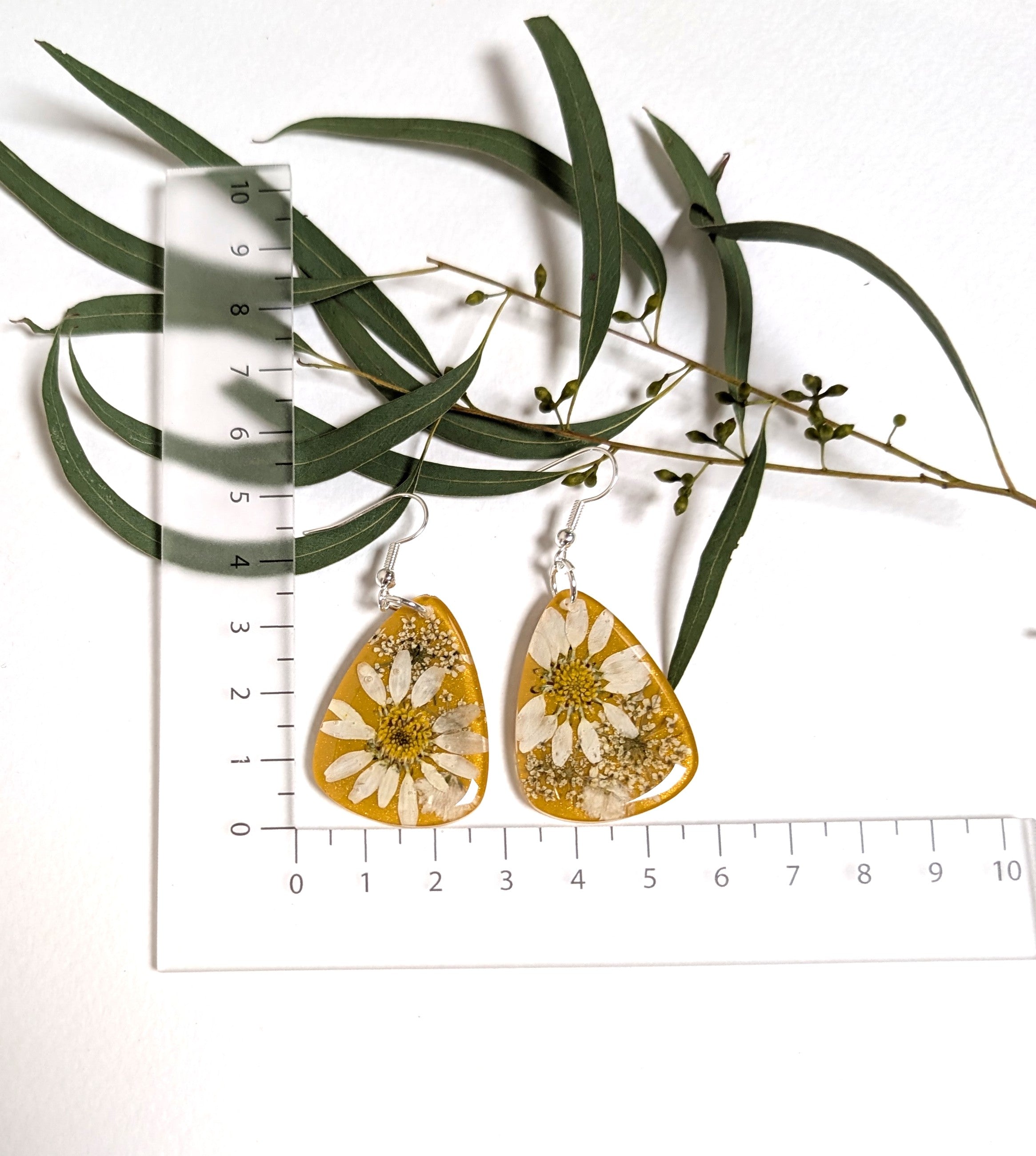 Real daisies in resin, mustard background