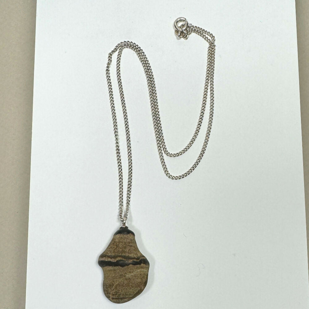 Pebble necklace on flat white background