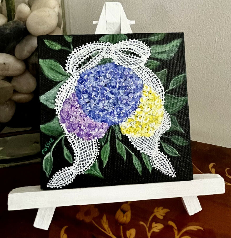 Miniature acrylic painting of flowers on a wooden easel