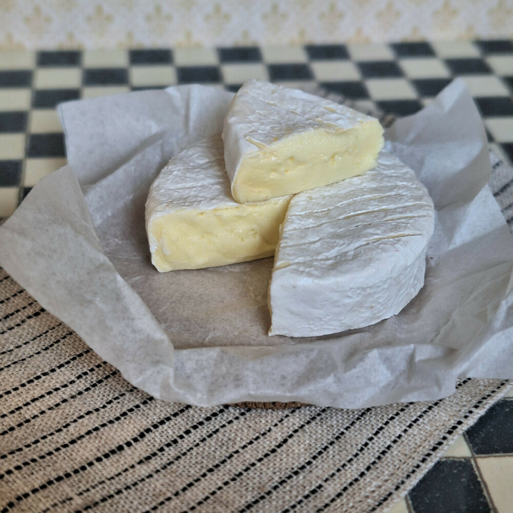 LARGE BRIE cheese with a cut wedge