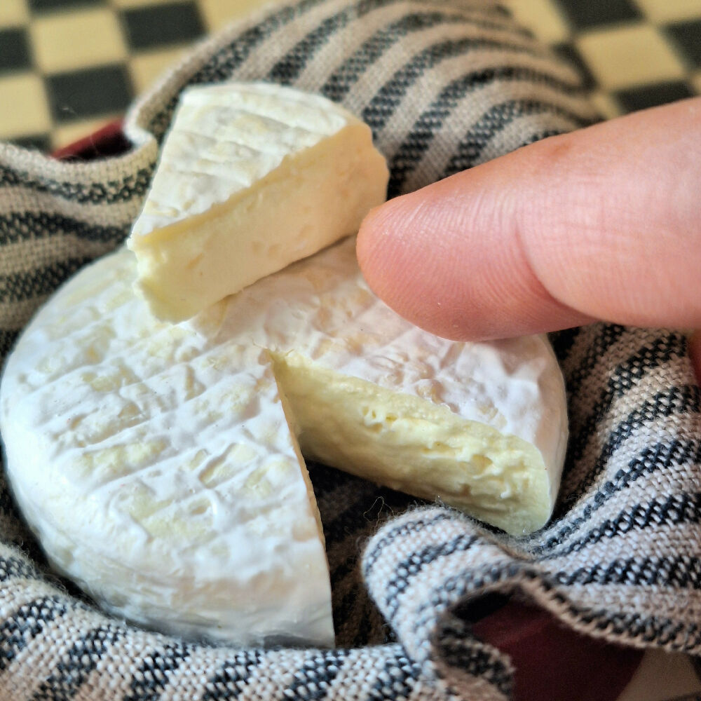 LARGE BRIE cheese with a cut wedge