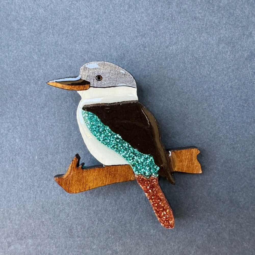 Australian-handmade-laughing-kookaburra-brooch-wood-glitter-resin-on-grey-background-square