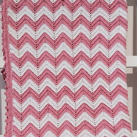 Pink and white cotton baby blanket.