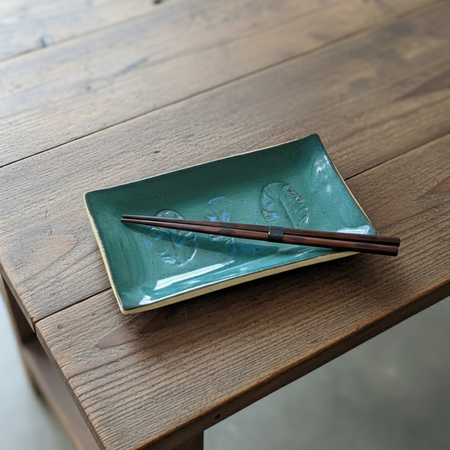 Ceramic Artisan-style sushi plate with a vibrant green glaze and leaf imprint.