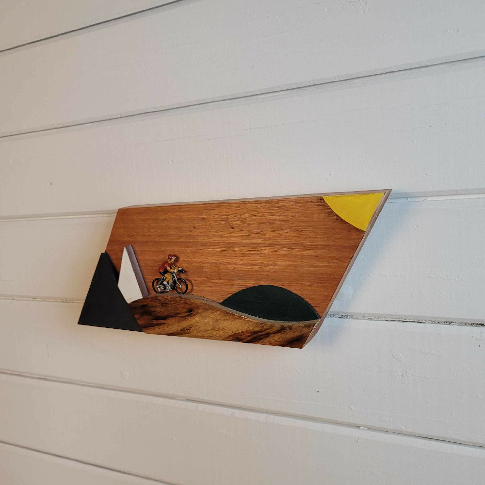 Retro vintage cyclist riding through a stylised mountain scene