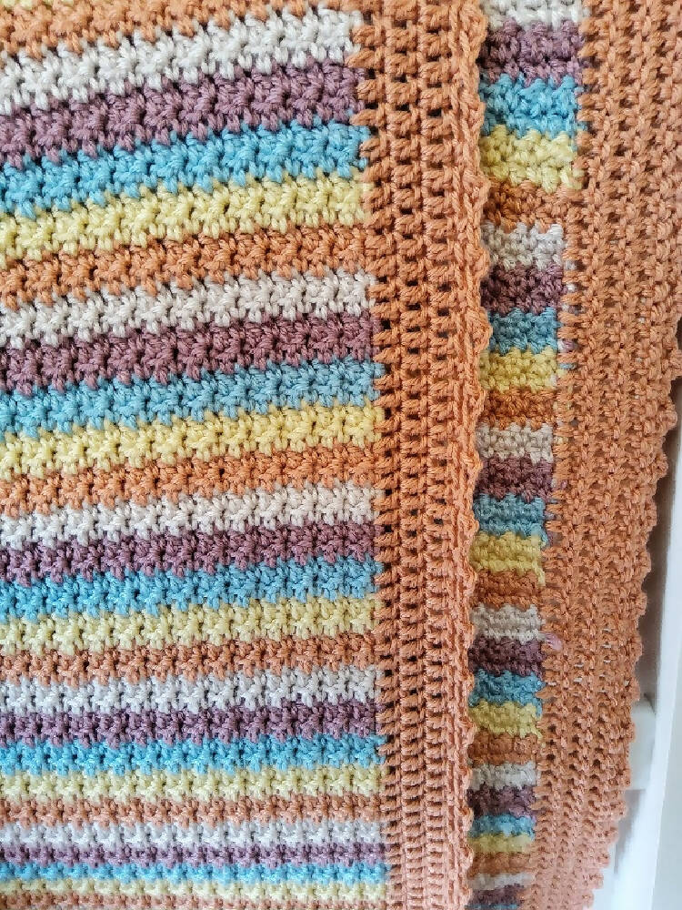Multi coloured crochet baby blanket.