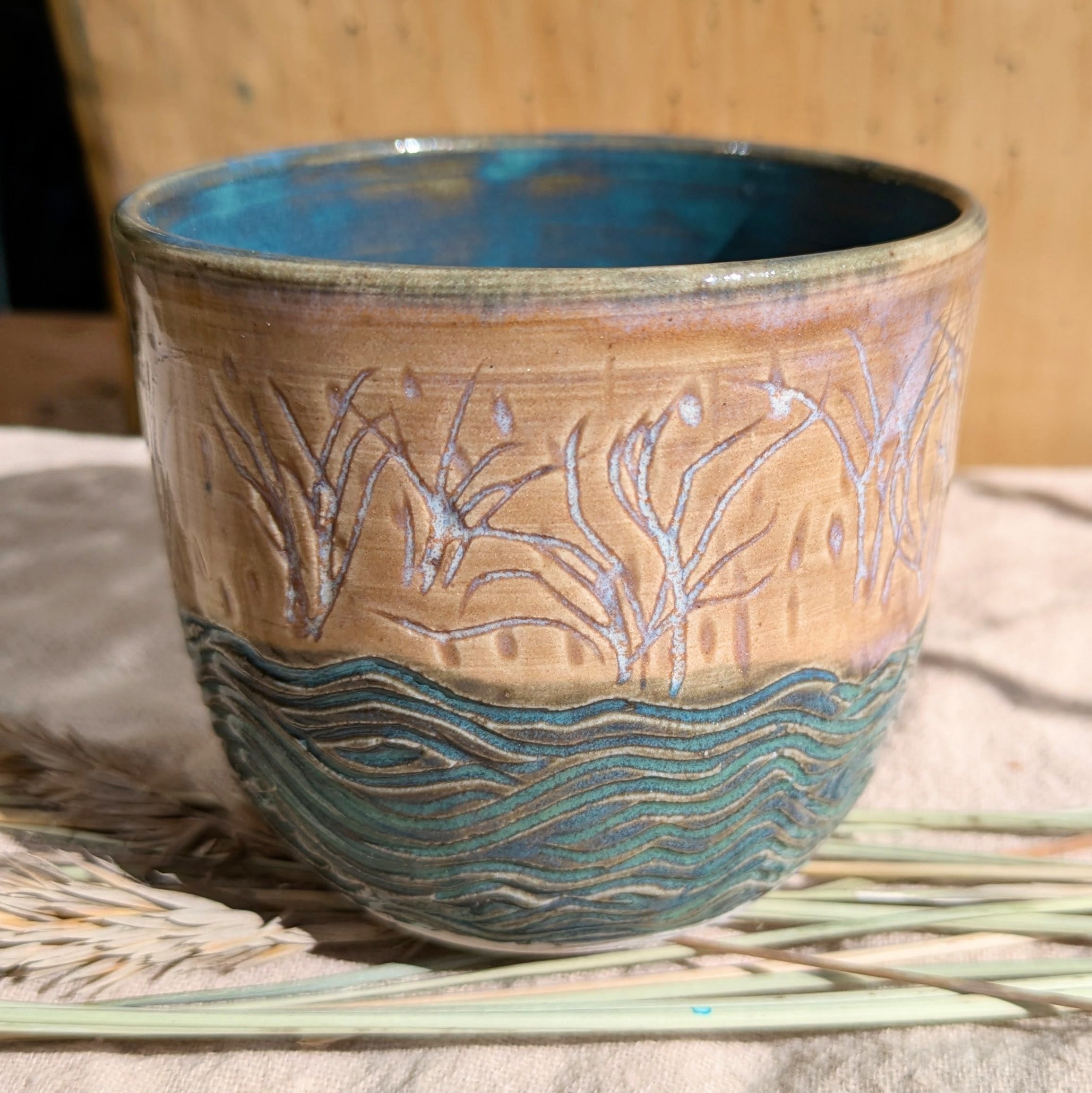 Sand dunes reeds and water tumbler