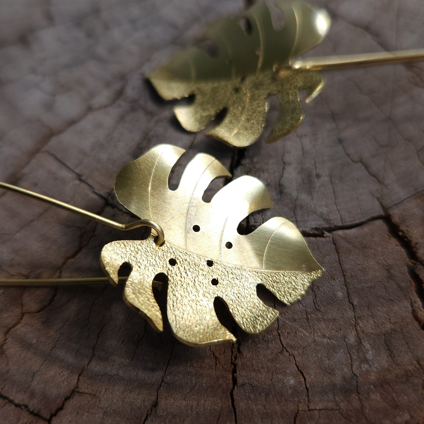 Golden tone monstera earrings