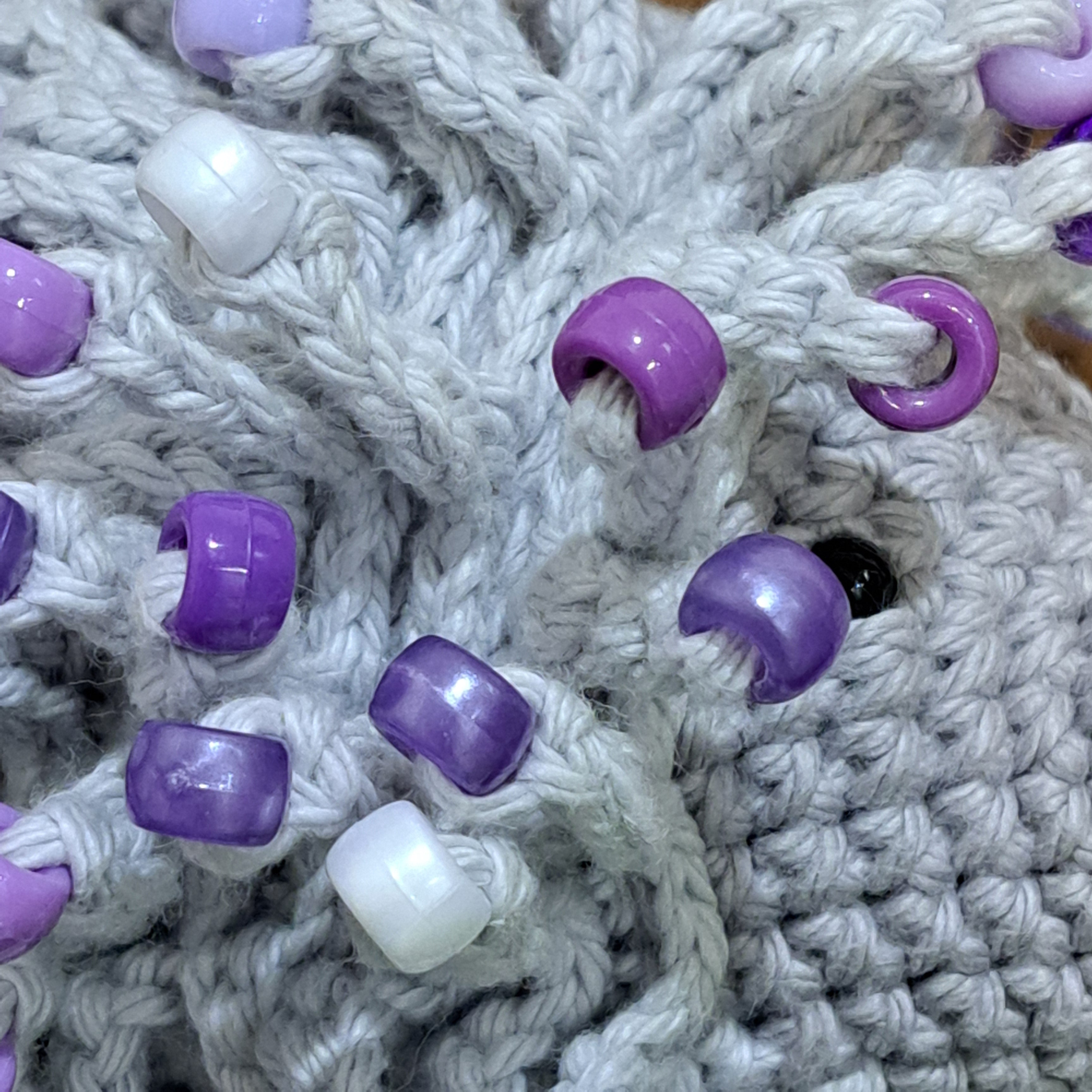 Handmade crochet echidna in grey cotton with mauve beads