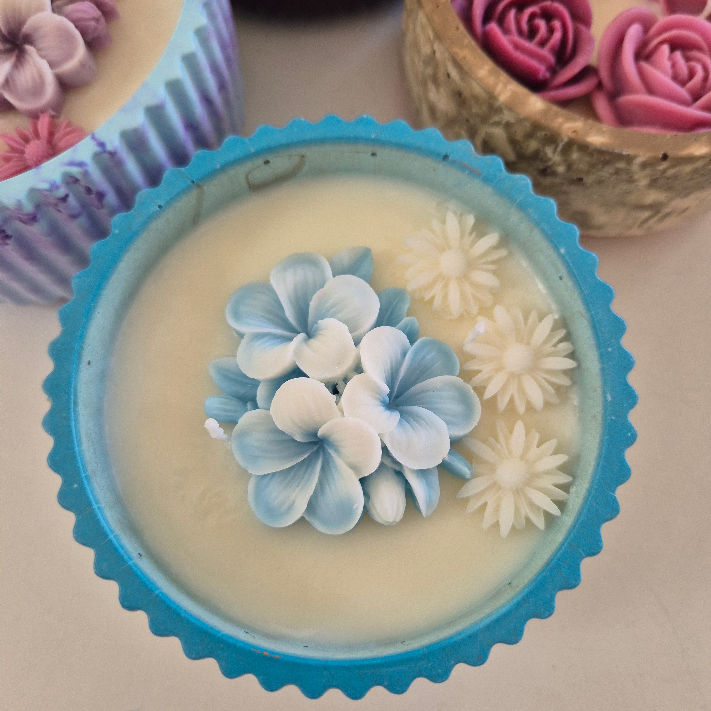 Round blue and gold concrete bowl candle with frangipani flower