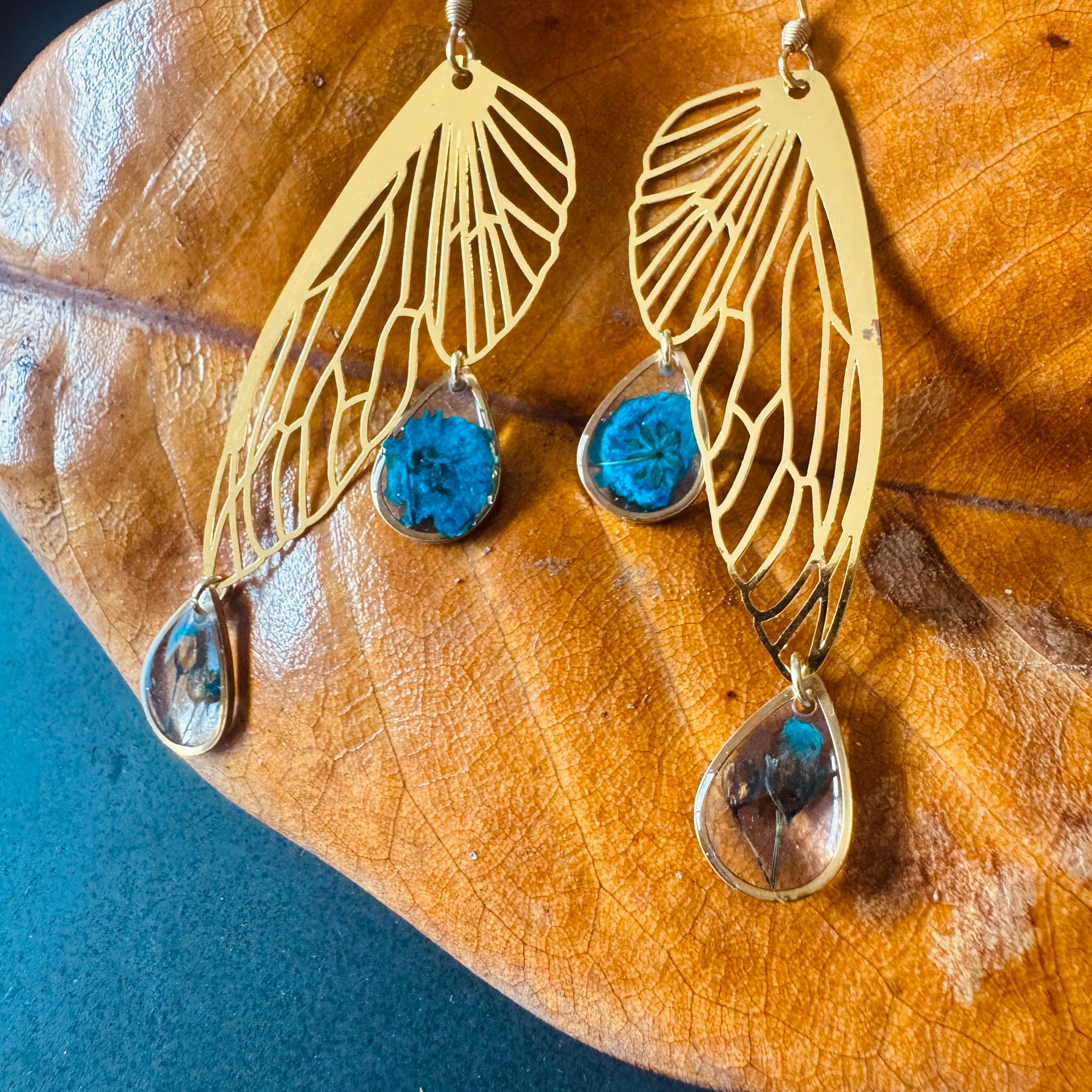 Butterfly resin earring with blue pressed flowers