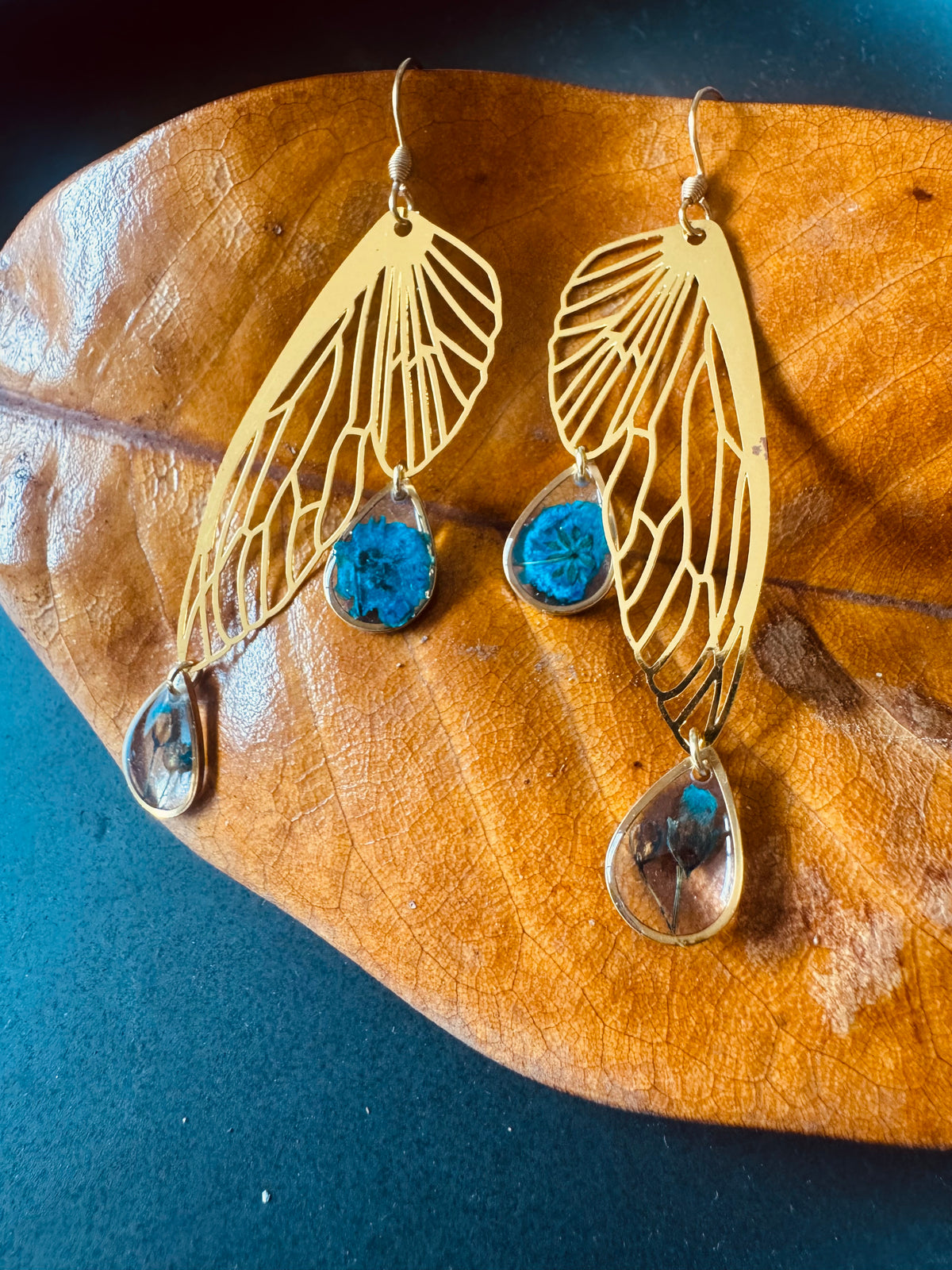 Butterfly resin earring with blue pressed flowers