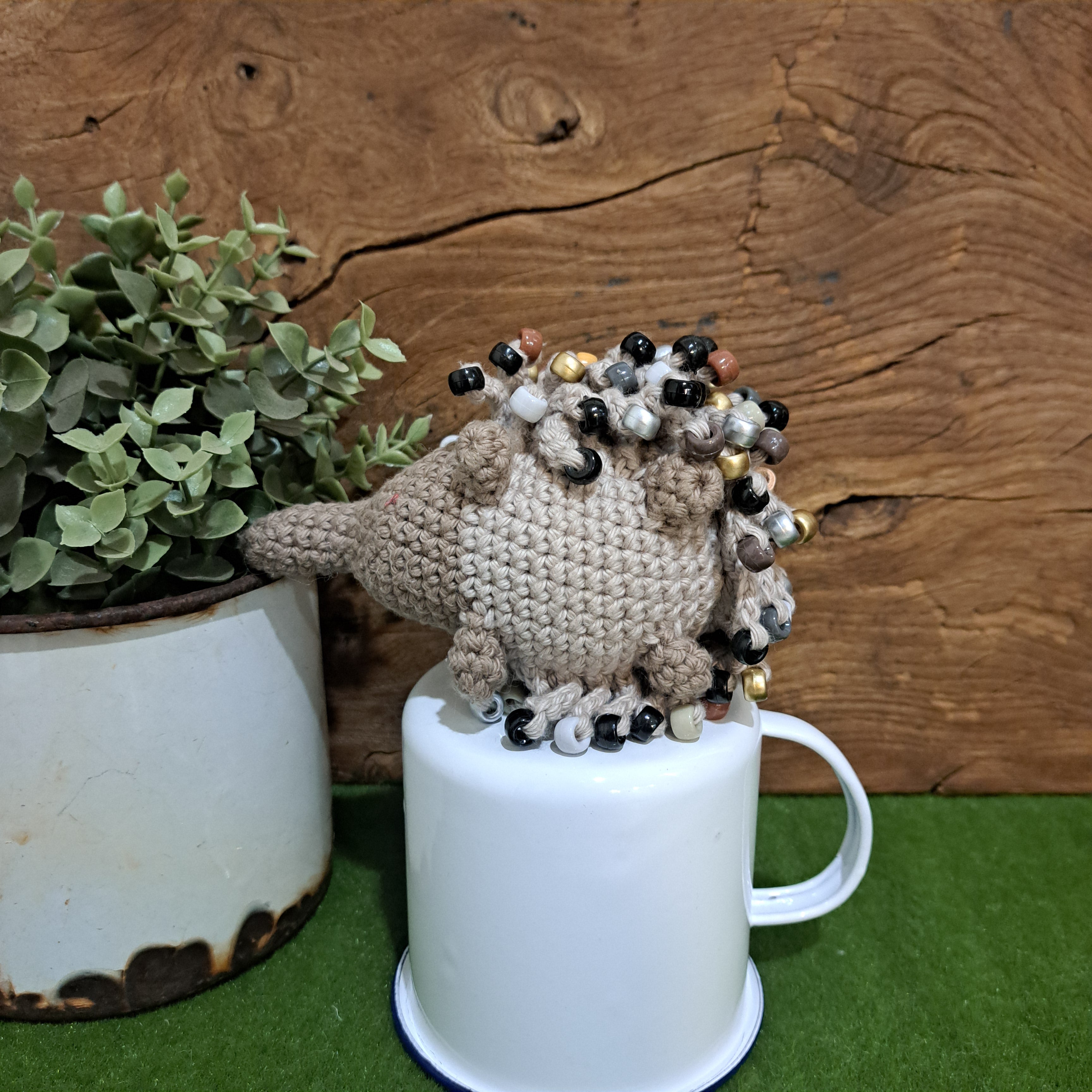 Handmade crochet echidna in beige cotton with neutral coloured beads