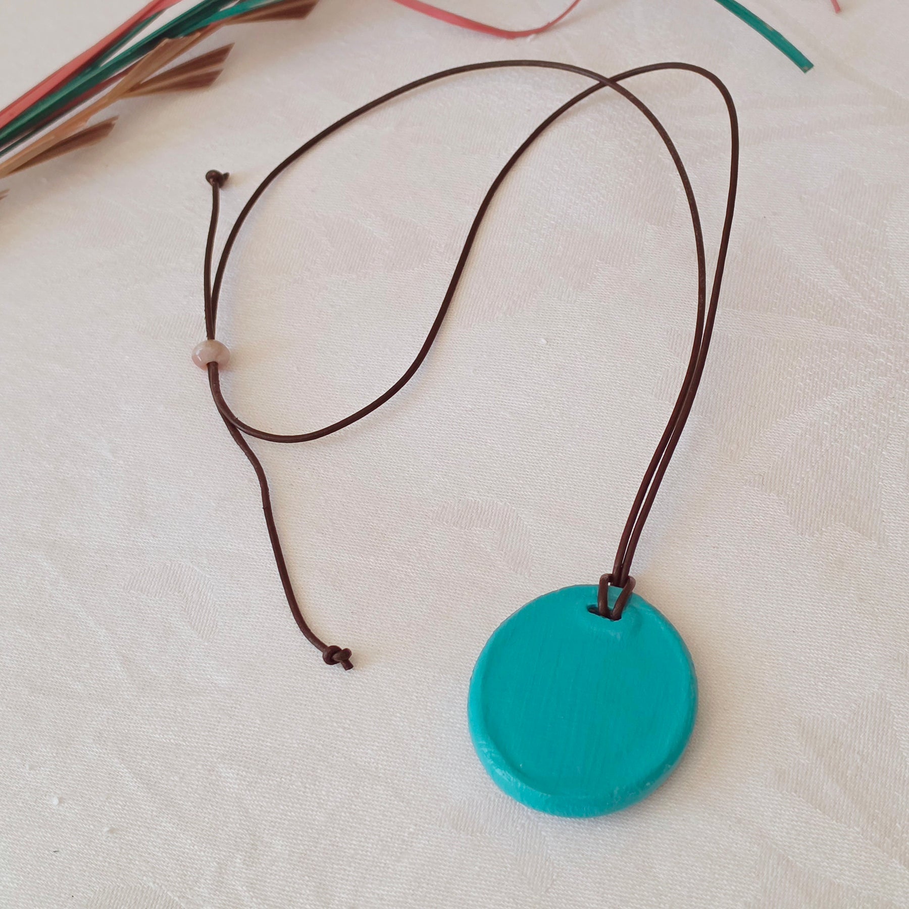 Hand-painted natural clay pendant with palm fibre heart