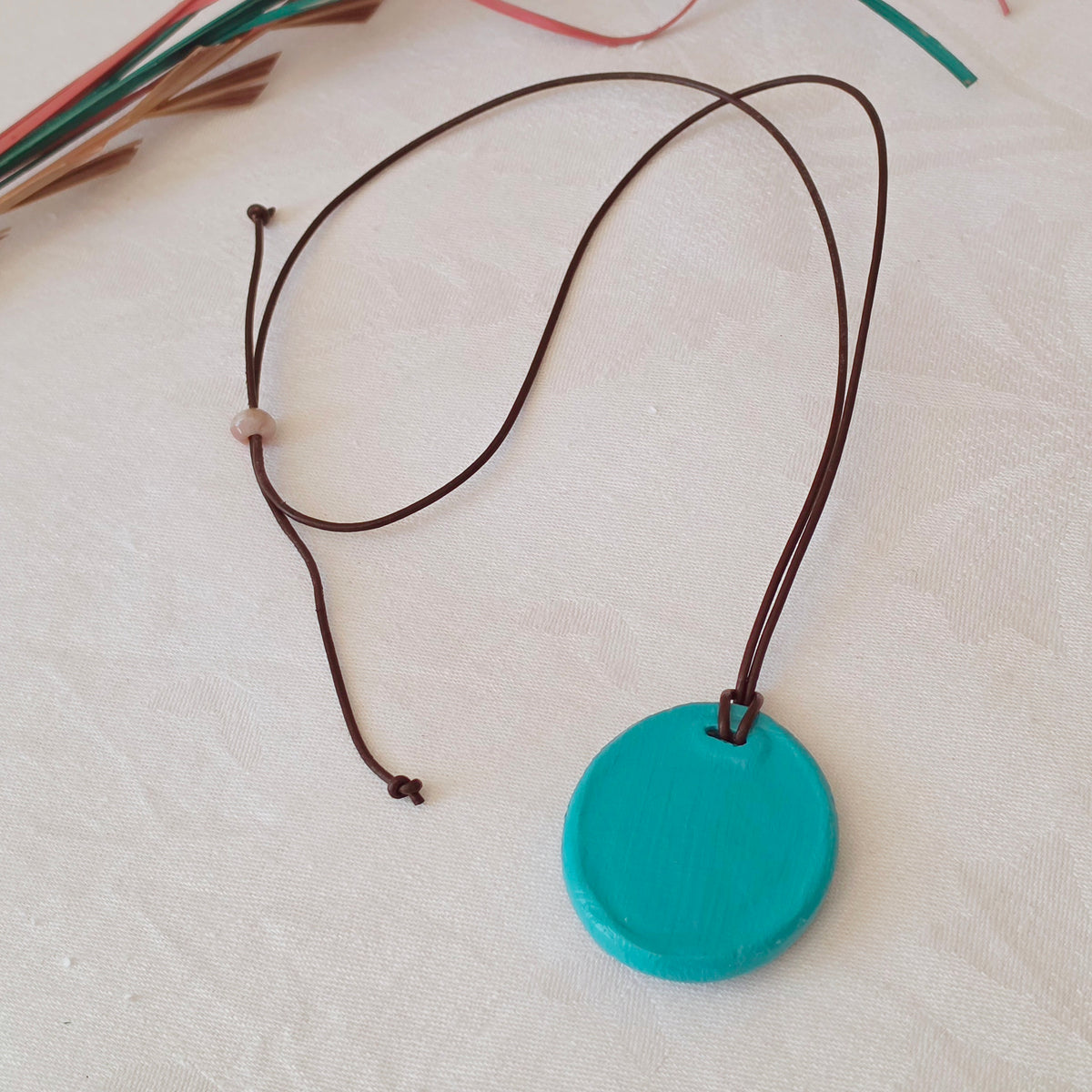 Hand-painted natural clay pendant with palm fibre heart