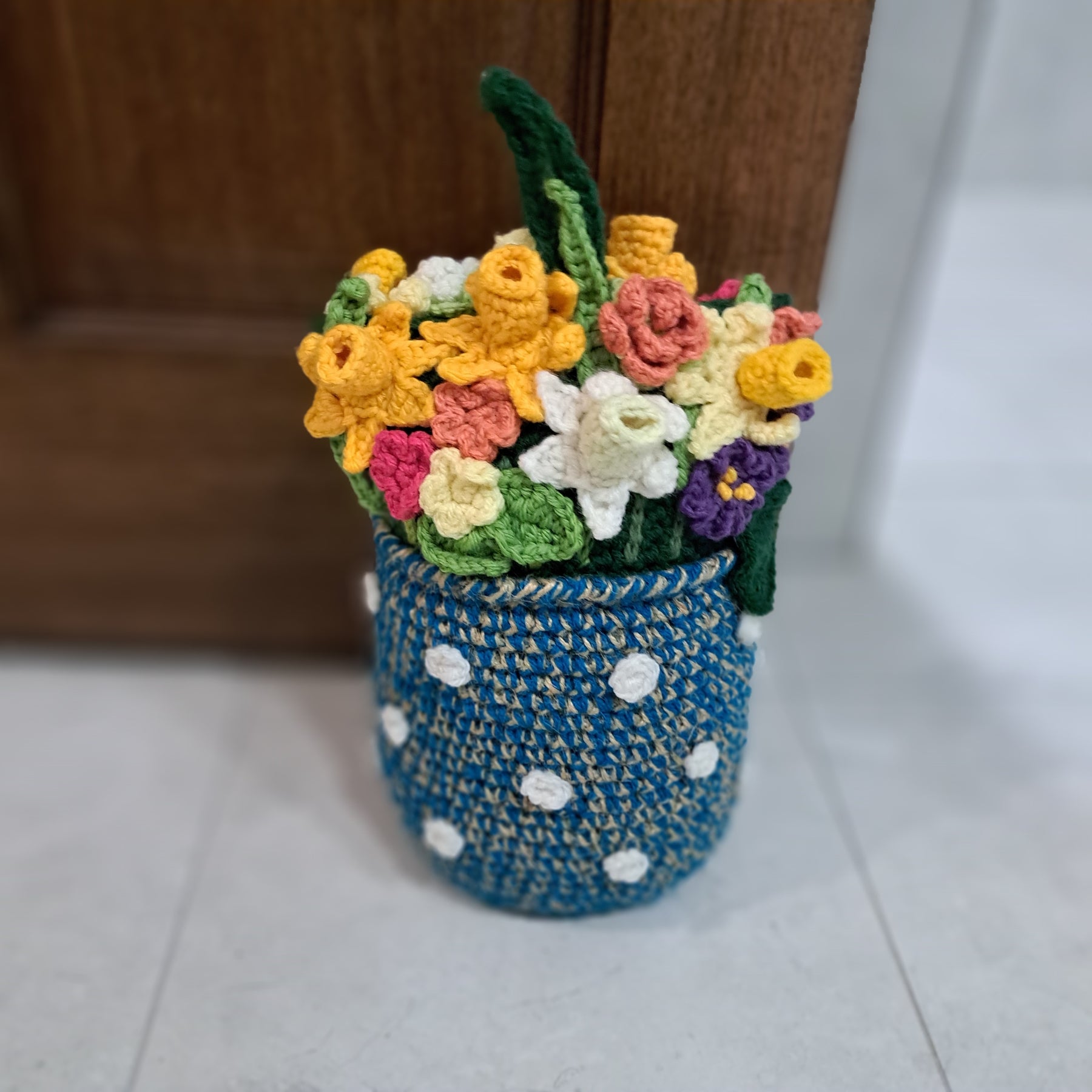 Crochet Doorstop vase of spring flowers.