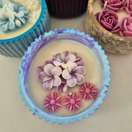 Round blue and purple concrete bowl candle with frangipani flower