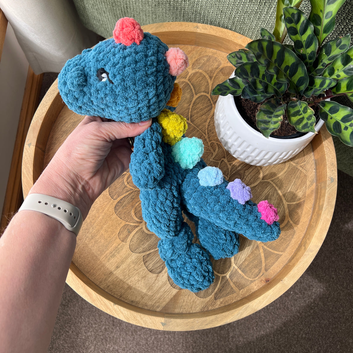 Handmade crochet Dinosaur modern lovey with knotted legs and rainbow spikes.