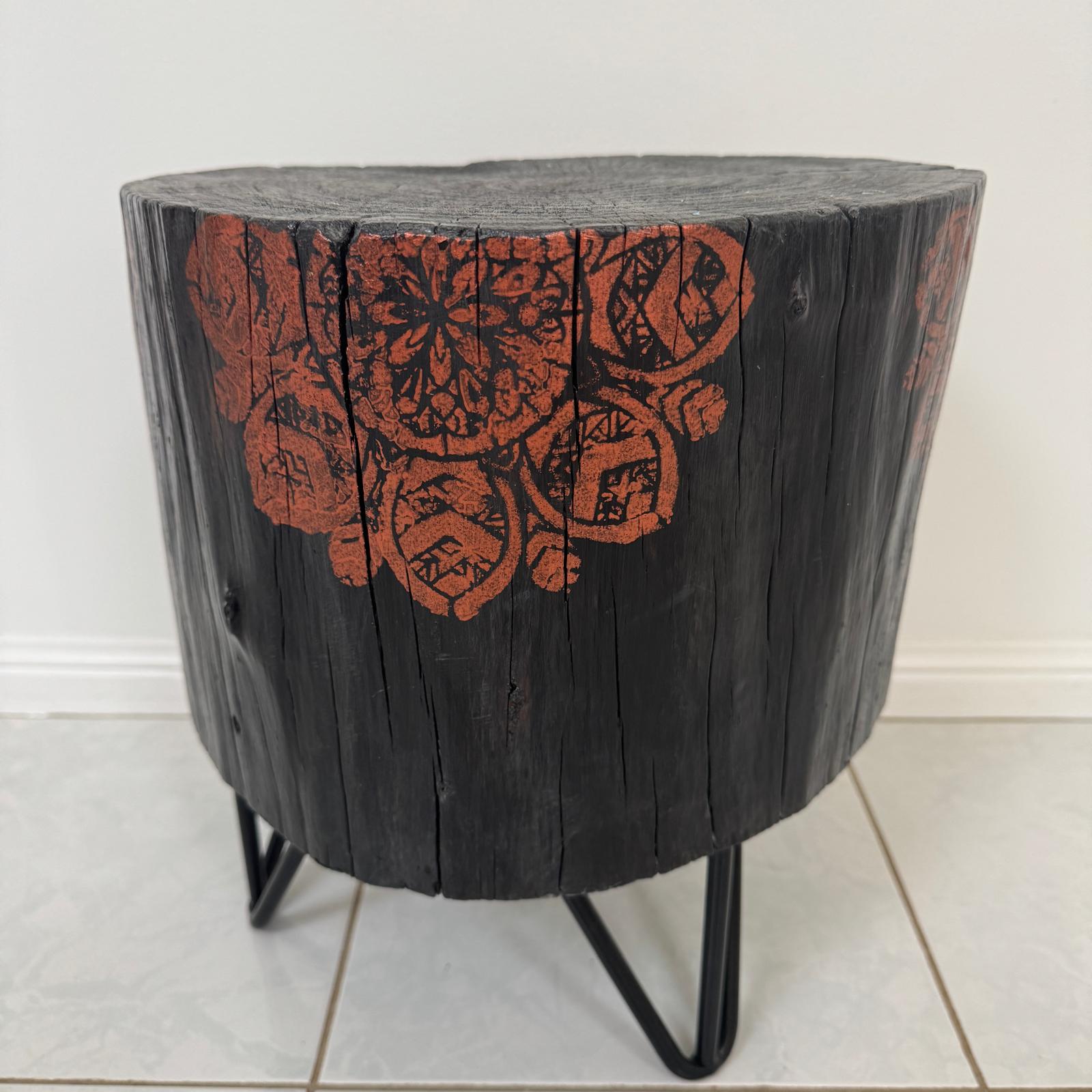 Burnt timber stump table featuring copper mandala artwork